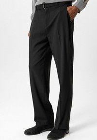 Zwarte broek met een rechte pijp, vervaardigd uit een gladde stof. Heeft een vlakke voorkant, lussen voor een riem en zijzakken.