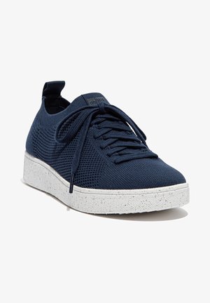 Zapatillas de punto en color marino con un upper texturizado, cordones planos y una suela blanca moteada. Punta redondeada y una etiqueta en el talón para facilitar su uso.