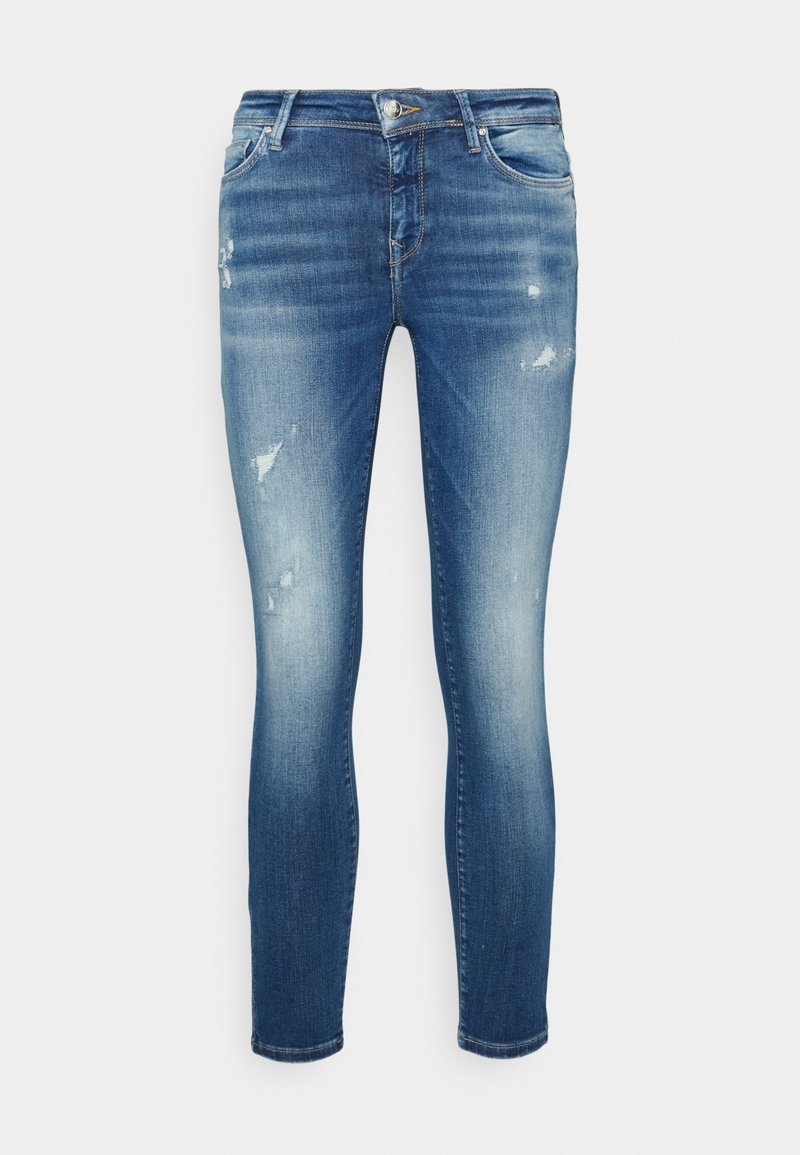 Jean skinny bleu délavé avec détails usés, design à cinq poches, fermeture avant par bouton et fermeture éclair.