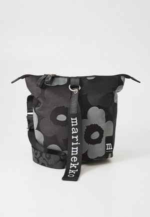 Black floral backpack made of durable fabric, featuring a zip closure, adjustable strap, and a logo detail in white.