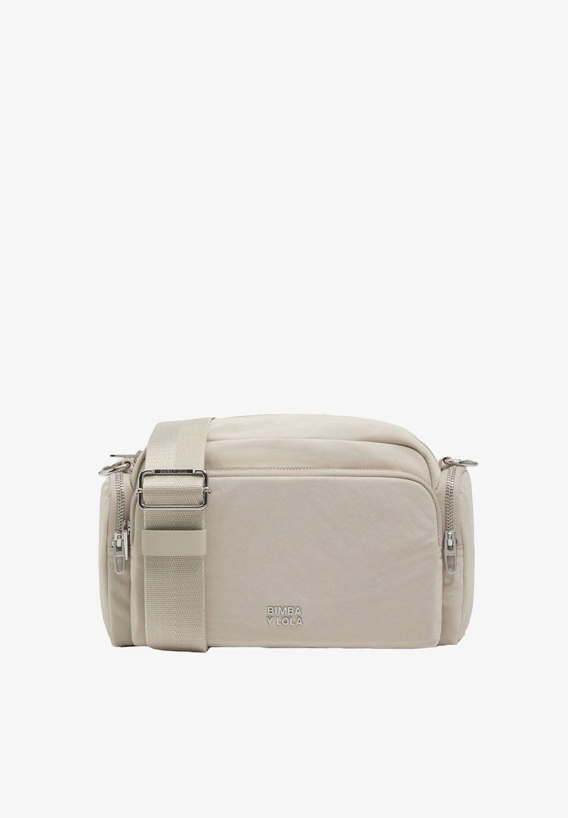 Beżowa torebka na ramię z miękkiego materiału, o ustrukturyzowanym kształcie, z dwoma zamykanymi na zamek przedziałami i regulowanym paskiem. Widoczna nazwa marki.