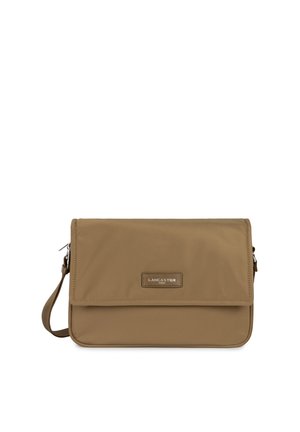 Tan canvas crossbody bag with a fold-over flap, logo plaque, and adjustable strap. Zip pocket on the back for additional storage.