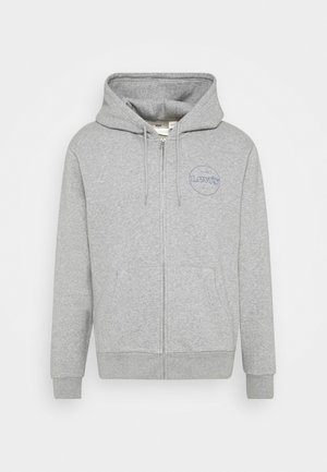 Jasnoszara bluza z kapturem i zamkiem błyskawicznym, kieszeniami z przodu, sznurkiem w kapturze, ściągaczami przy rękawach i logo Levi's na lewej piersi.