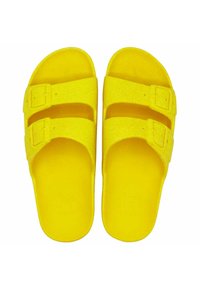 Sandales jaunes en plastique pailleté, avec deux brides ajustables munies de boucles. Forme arrondie et semelle intérieure texturée.