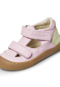Light pink leather sandal with dual Velcro straps, open toe design, textured tan rubber sole, and soft inner lining.