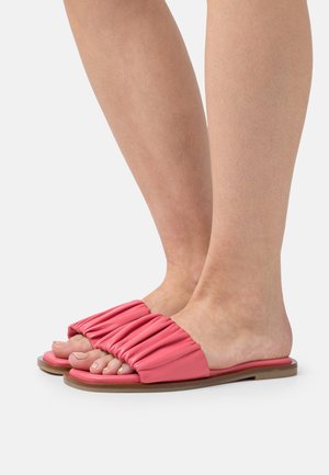 Rosa halkskyddsandaler med en samlad remdesign som visar tårna. Mjukt material och platt sula med en slät finish.