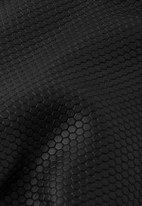 Schwarzer Strukturstoff mit hexagonalem Muster und einer glatten Oberfläche, die Licht reflektiert und das geometrische Design betont.