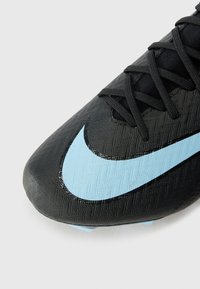 Black soccer cleat with textured synthetic upper, featuring a large light blue swoosh design and black laces, highlighting sporty functionality.