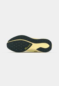 Suela de zapato con una superficie de goma negra texturizada, con una entresuela amarilla. El texto "NIKE STORM-TREAD" es visible en negrita en el costado.