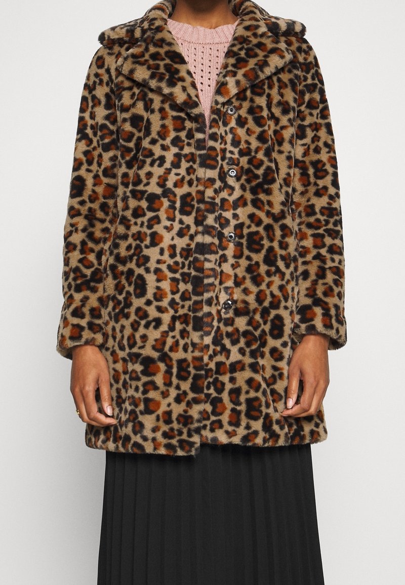 Leopardmönstrad fuskpälsjacka med en mjuk textur, stor krage, knappstängning och knälång design, bärs över en rosa stickad topp.