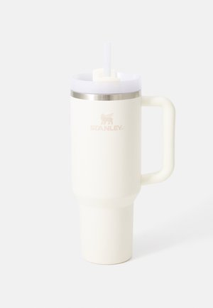 Cana de călătorie din oțel inoxidabil alb, cu o formă conică, mâner robust, bandă argintie, pai integrat și logo-ul 'STANLEY' într-o finisare subtilă.