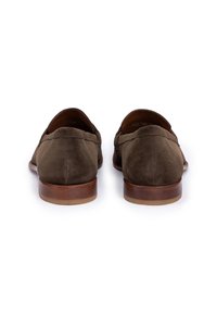 Mocassins en daim vert olive avec un bout arrondi, un talon en bois plat et des détails de couture minimalistes. Texture lisse et design classique.