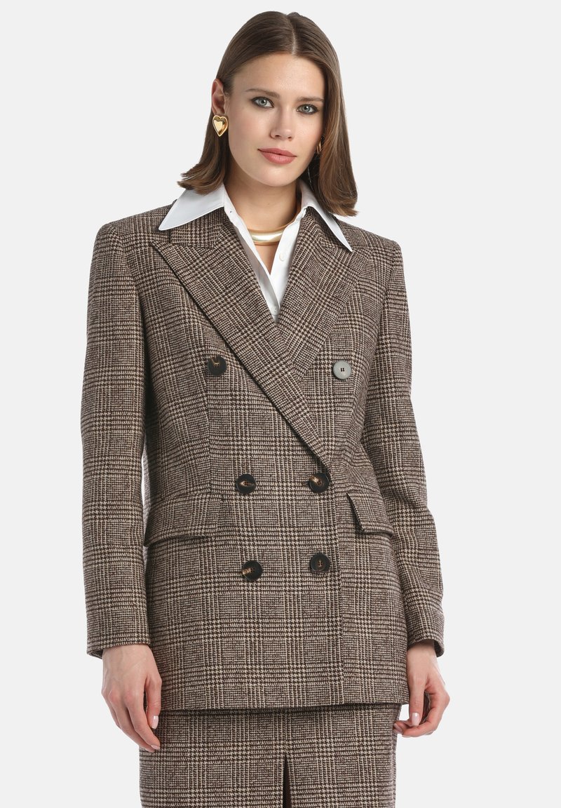 Double-breasted wool blazer in a brown and black check pattern. Features large buttons, lapel collar, and is tailored for a structured fit.