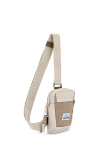 Borsa a tracolla beige realizzata in tessuto resistente, con un pannello frontale texturizzato, tracolla regolabile e chiusura con zip dotata di un anello per accessori.