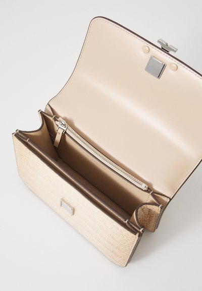 Cream-colored handbag with a textured crocodile pattern, silver hardware, a zippered compartment, and an open flap design.