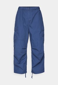 Sinisiä työvaatehousuja, joissa on joustava vyötärö, nappisuljenta, sivutaskut ja kiristysnyörit lahkeissa. Kevyet housut, joissa on sileä kangas.