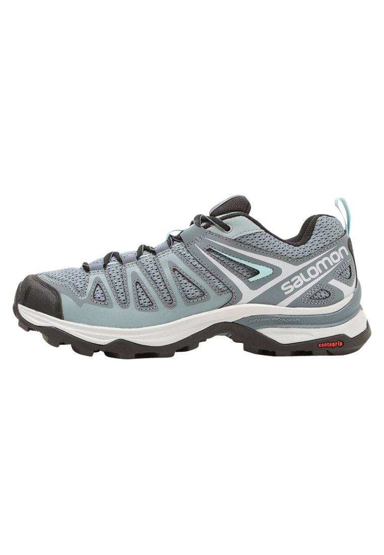 Chaussure de randonnée gris clair avec tige en mesh, capot en caoutchouc à l'avant, semelle intermédiaire blanche et semelle extérieure noire. Présente un logo de marque proéminent et des accents de design.