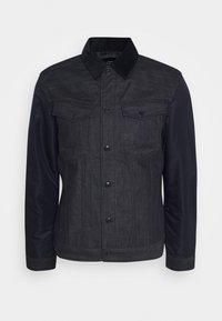 Jeansjacka med mörkgrå kropp och marinblå ärmar, med krage, två bröstfickor och tryckknappsstängning.