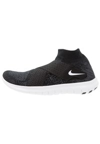 Baskets de sport noires avec un dessus en tricot, panneaux en mesh, une large sangle et une semelle extérieure blanche avec une texture antidérapante. Logo Nike sur le côté.