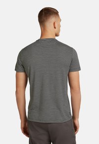 Krátký rukáv tričko v černobílých pruzích, design s kulatým výstřihem, bavlněný materiál, úzký střih, s malým logem na lemu.