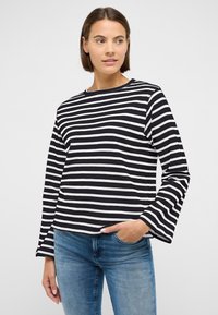 Triibuline pikkade varrukatega pluus tumepunases ja valges, ümar kaeluse ja laperdavate varrukatega, valmistatud siledast puuvillasegu kangast.