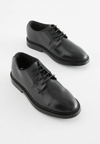 Czarne skórzane buty na sznurówki o gładkim wykończeniu, z okrągłym noskiem i kontrastującą czarną podeszwą. Minimalistyczny design z detalami tonalnego przeszycia.