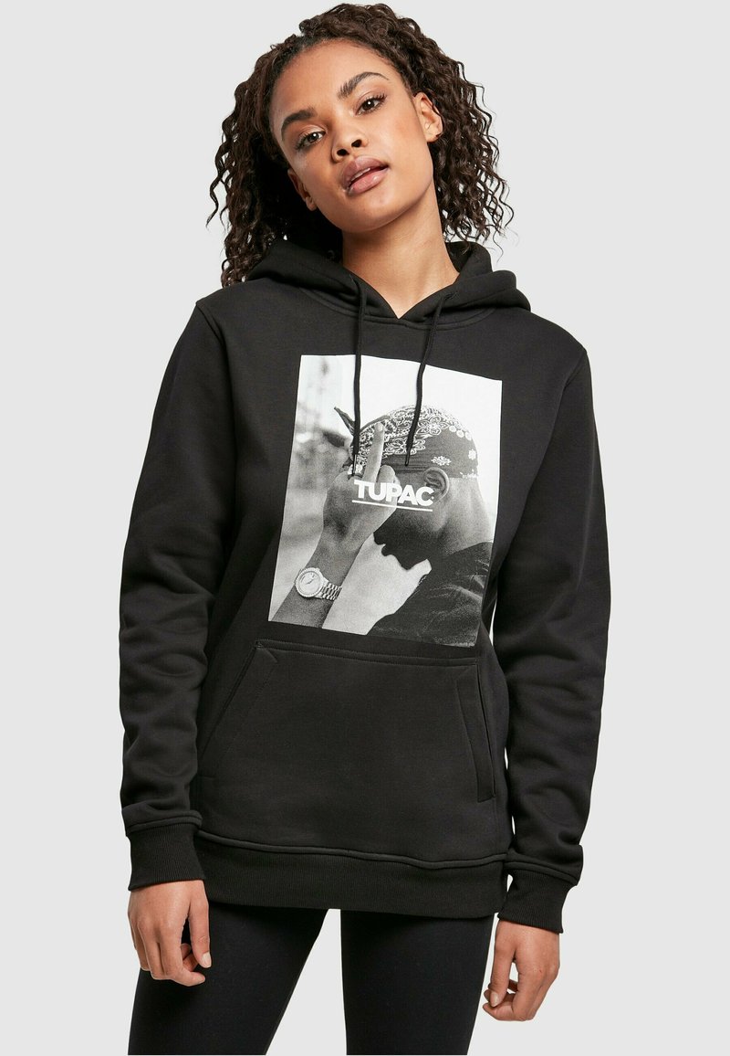 Sudadera negra con un gráfico de una figura que lleva un pañuelo. Bolsillo delantero y cordones en la capucha. Material textil suave.