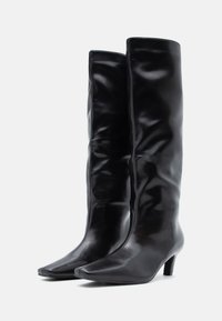 Μαύρες μπότες μέχρι το γόνατο από λείο δέρμα, με κομψό σχέδιο, μυτερές μύτες και χαμηλά τακούνια. Χωρίς ορατά μεταλλικά μέρη ή σχέδια.