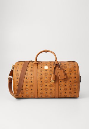 Sac de voyage en cuir tan avec un motif de logo embossé, deux poignées, une bandoulière amovible et une étiquette de bagage. Accent en matériel doré.