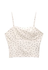 Hvid cropped top med tynde stropper, der har en tekstureret stof og sorte prikker. Klassisk firkantet udskæring og tætsiddende design.