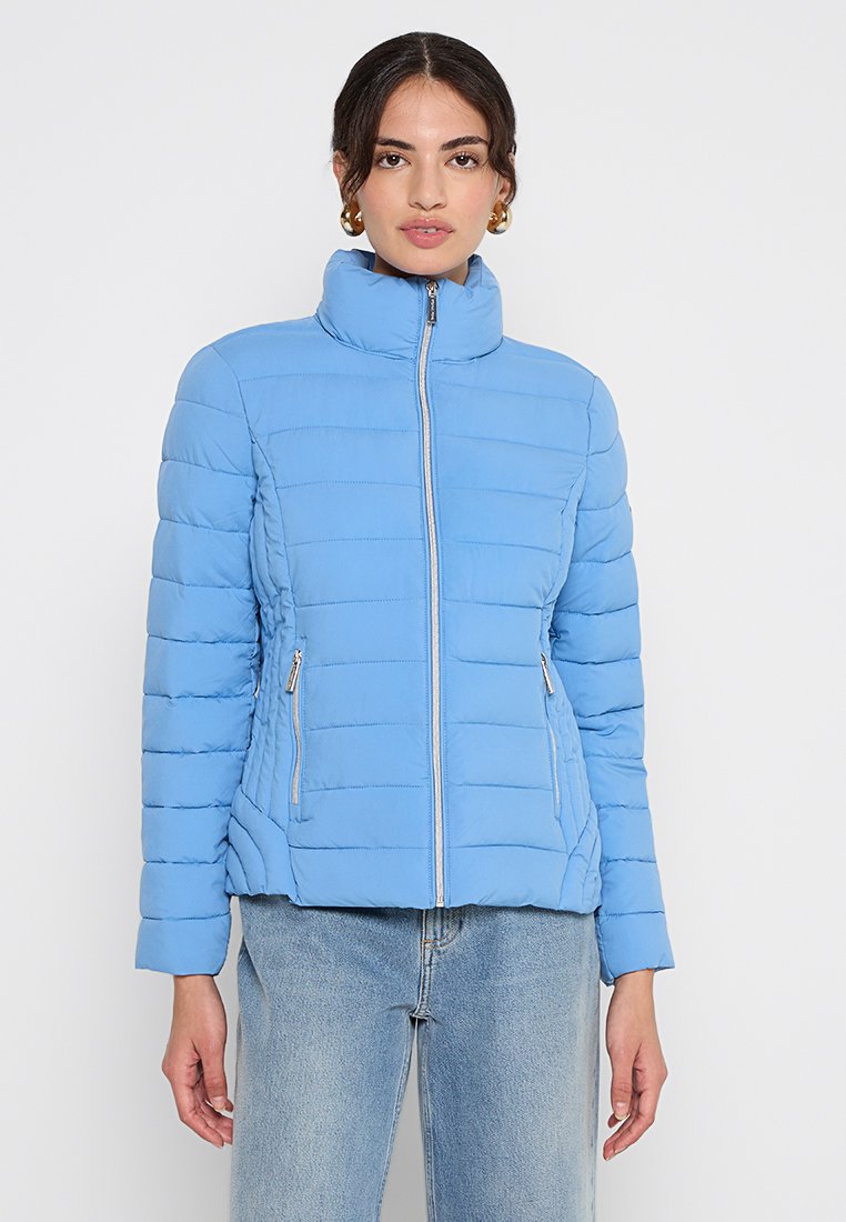 Hellblau gesteppte Daunenjacke mit hohem Kragen, Frontreißverschluss und zwei seitlichen Taschen. Verfügt über ein gesteppte Design und eine weiche Textur.