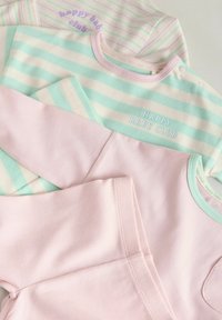 Collection de hauts pour bébé aux couleurs pastel. Tissu rayé vert menthe et rose avec texte brodé, texture douce et pressions snap.