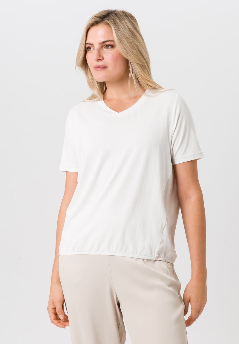 Witte katoenen V-hals t-shirt met korte mouwen, met een relaxte pasvorm en subtiele zijnaaddetails. Soepele textuur, zonder patronen.
