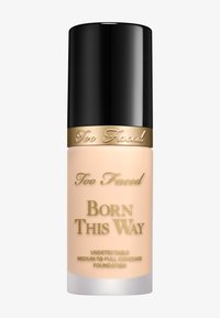 Too Faced Born This Way Foundation in einer mattierten Glasflasche, hellbeige Farbton, zylindrische Form, schwarzer Deckel und goldene Schriftzugdetails.