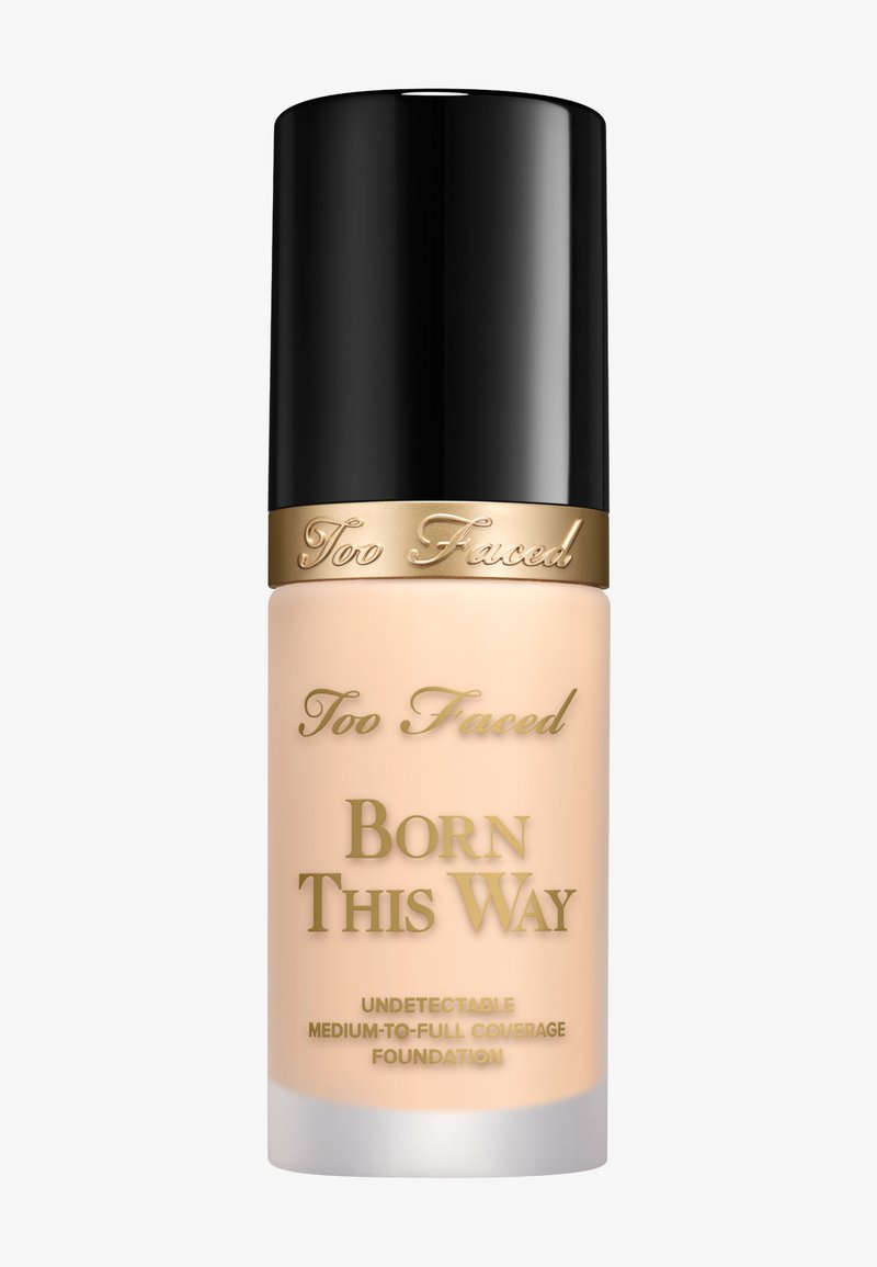 Too Faced Born This Way foundation in een mat glazen flesje, lichtbeige kleur, cilindrische vorm, zwarte dop en gouden tekstdetails.