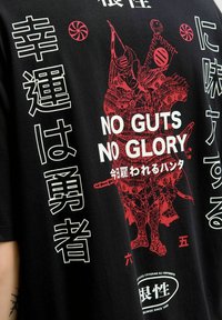 Zwarte katoenen t-shirt met rood en witte grafische tekst, een samurai-illustratie en verschillende Japanse karakters met een rond logo.