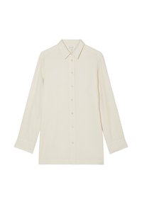 Maglietta lunga beige chiaro realizzata in tessuto morbido, con chiusura a bottoni, colletto classico e taglio dritto con maniche cuffiate.