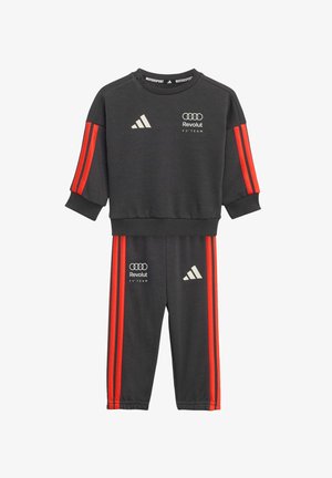 Tummanharmaa verkkapuku punaisilla raidoilla, jossa on kirjailtu logo rinnassa ja reidessä. Pehmeä kangas, rento istuvuus, resorit hihansuissa.