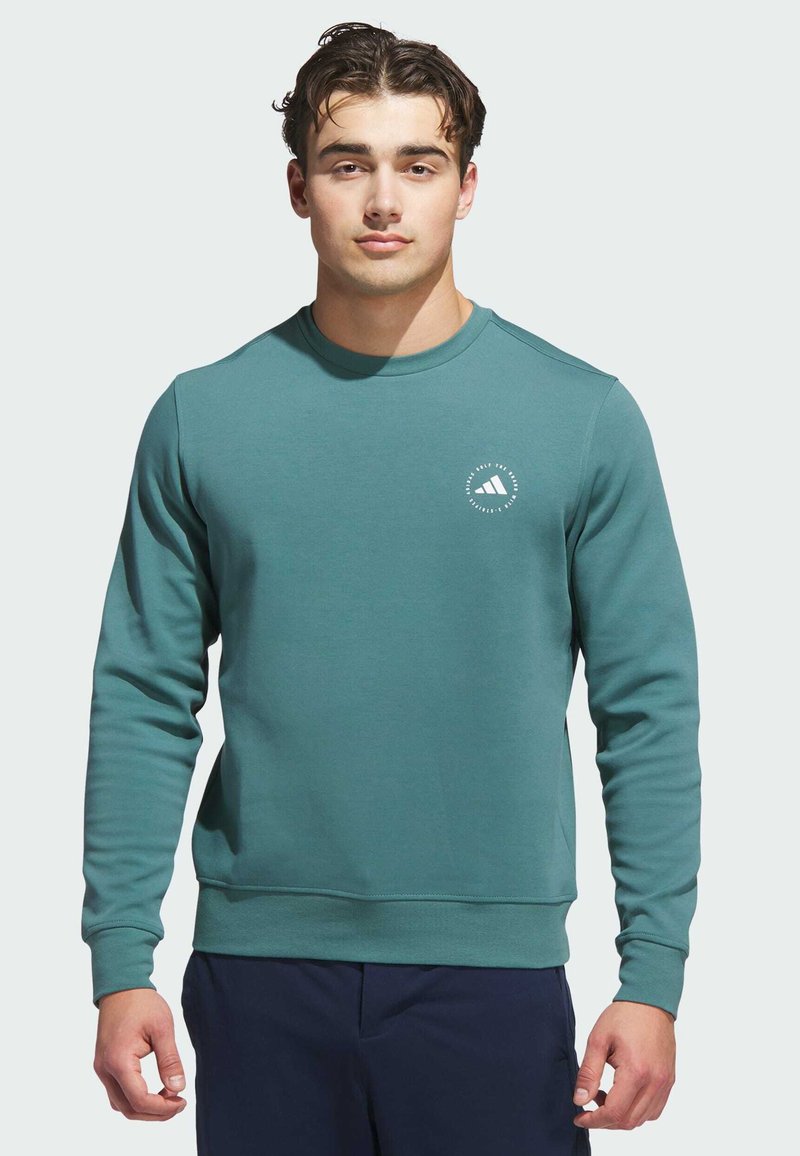 Teal sweatshirt with crew neck, long sleeves, ribbed cuffs and hem, featuring a small white logo on the chest. Smooth texture. Casual fit.