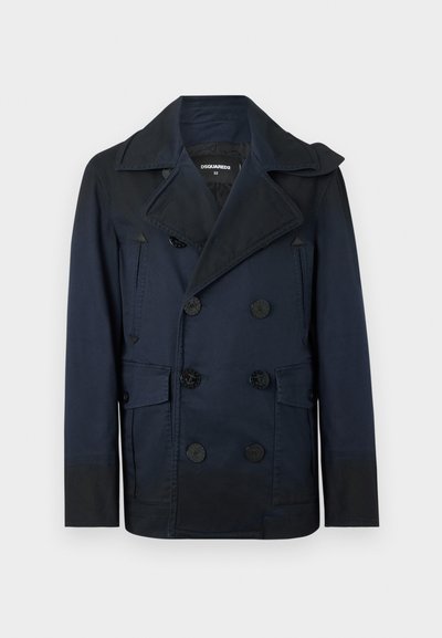 Manteau caban bleu marine à double boutonnage avec large col, six boutons noirs, deux poches à rabat et deux poches verticales zippées.