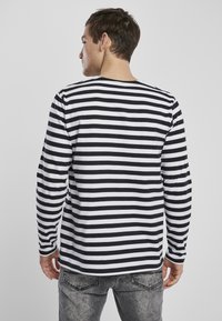 T-shirt met lange mouwen, voorzien van zwart-witte horizontale strepen, gemaakt van katoen, met een ronde hals en een relaxte pasvorm.