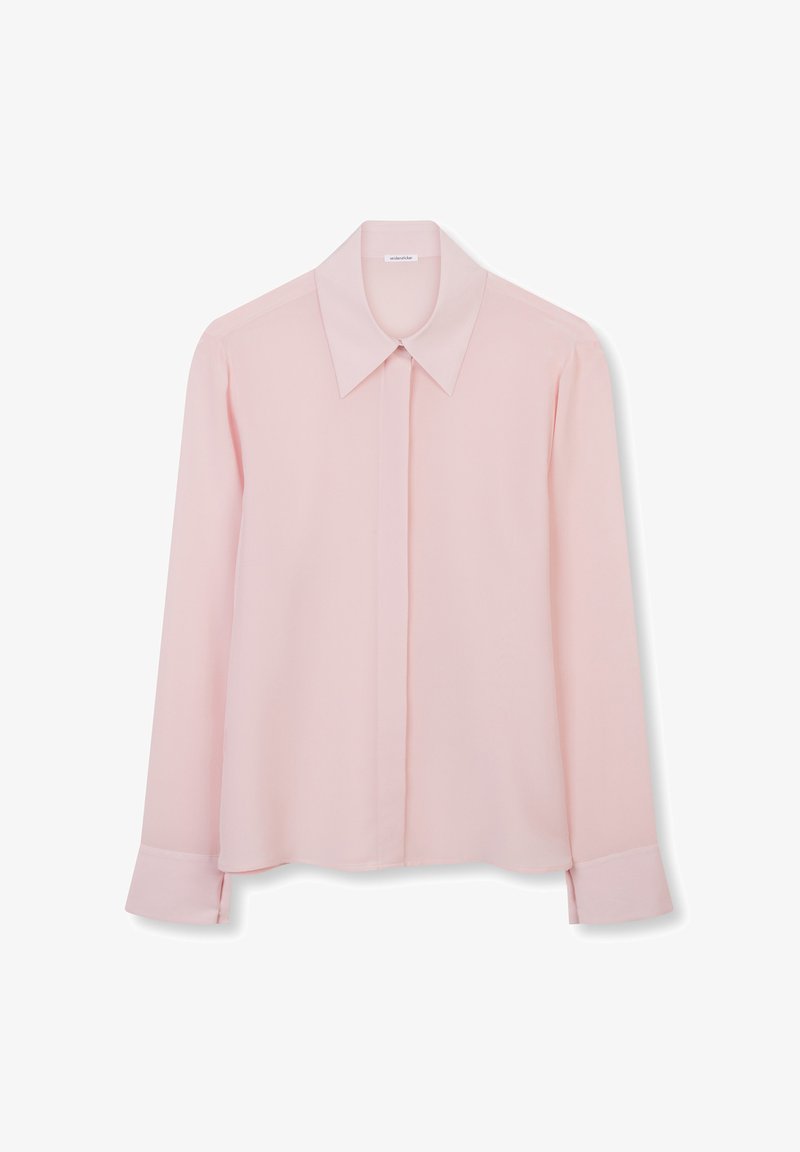 Blouse rose clair à manches longues avec col pointu, patte de boutonnage dissimulée et larges poignets, présentée sur un fond blanc.