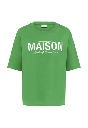 Vihreä puuvillainen T-paita, jossa on väljä malli, lyhyet hihat ja valkoinen painettu teksti, joka sanoo "MAISON" pienemmän tekstin kera alla.
