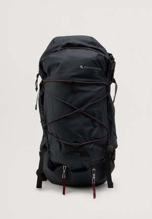 Zwarte nylon rugzak met een gestroomlijnd ontwerp. Voorzien van een bungee koordensysteem, verstelbare banden en metalen hardware accenten.