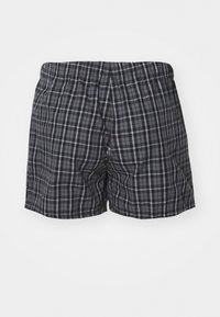 Boxers a cuadros en negro y gris con cintura elástica, que presentan una tela suave y un corte holgado. Patrón de cuadros visible en toda la prenda.