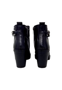 Stivali ankle in pelle nera con tacco alto, chiusura con zip e dettaglio decorativo a fibbia sul lato; texture liscia e forma strutturata.