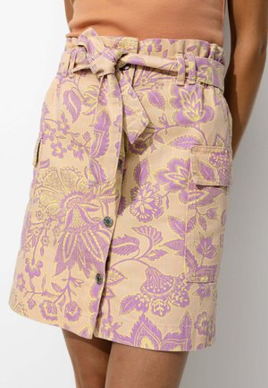 Jupe à motifs floraux en beige clair avec des accents violets et jaunes, dotée d'une taille à nouer, de boutons et de poches latérales.
