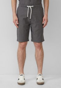 Grijze gestreepte shorts met een elastische tailleband en witte trekkoord, voorzien van een platte voorkant en zijzakken, gecombineerd met witte sneakers.