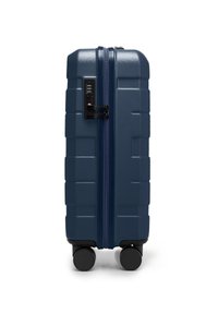 Valigia rigida blu navy con superficie texture, doppie ruote, serratura a combinazione e chiusura con zip. Design rettangolare con finitura opaca.