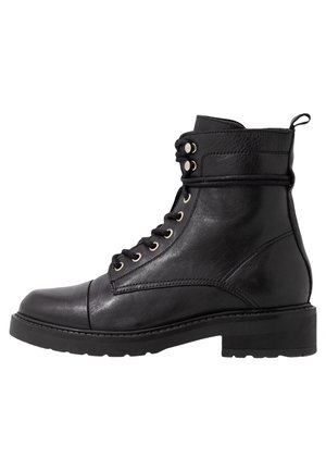 Botín negro de cuero hasta el tobillo con punta redonda, cordones en la parte frontal, ojales de metal y suela de goma resistente. Textura suave con acentos mínimos.